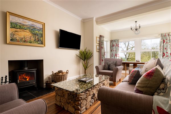 Sitting room with seating, bay window and wood burner