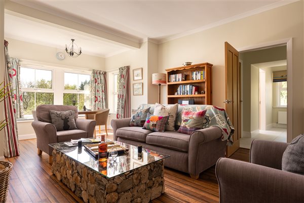 Sitting room with seating, coffee table and bay window