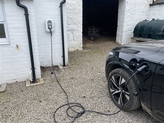 The cottage's EV charger plugged in to a car