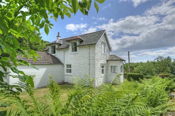 Two storey white painted cottage in pretty garden