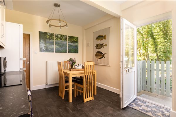 Kitchen has table and chairs and door to patio and enclosed garden