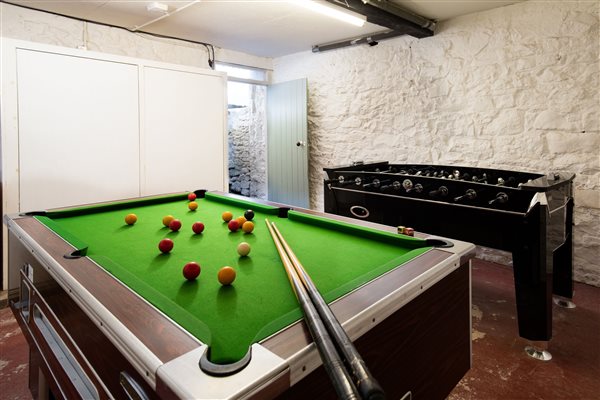 Games room in basement with pool table and table football