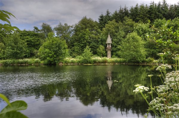 Orroland Loch with landscaped grounds and a round tower with turret style roof