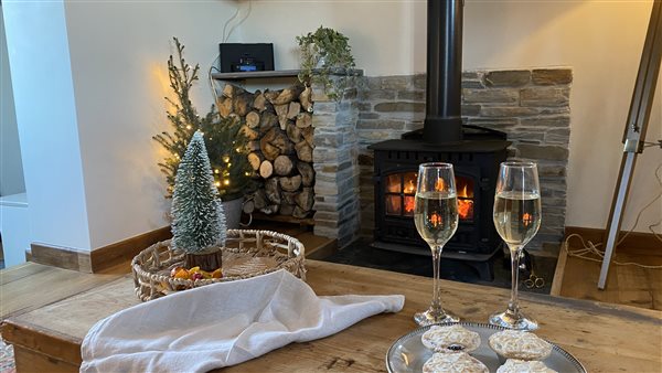 Champagne, Christmas decorations and lit log burner